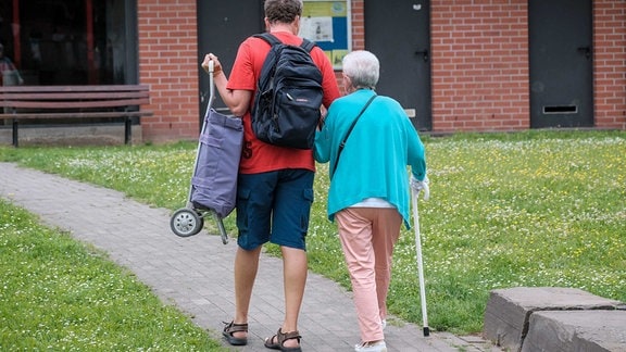 Einkaufshelfer unterwegs mit einer älteren Dame