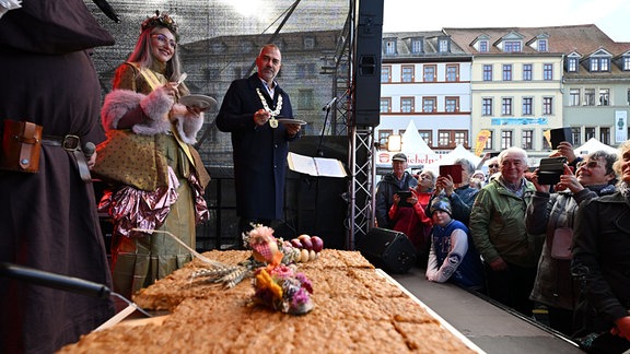 Weimars OB Peter Kleine und Zwiebelmarkt-Königin Sarah II. verkosten bei der Eröffnung des Zwiebelmarkts am 11.10.24 Zwiebelkuchen