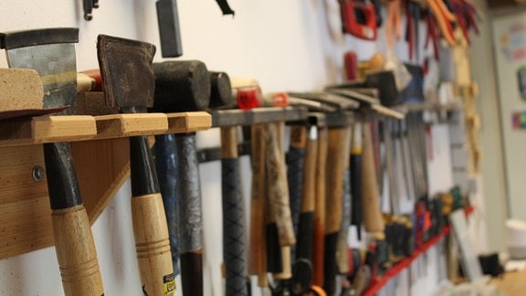 Verschiedene Werkzeuge hängen an einer Wand.
