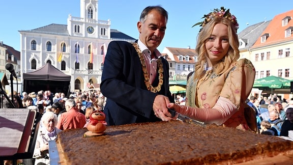 Peter Kleine und Caroline Kopp eröffnen 2022 den 369. Zwiebelmarkt mit dem traditionellen Anschnitt eines Zwiebelkuchens.