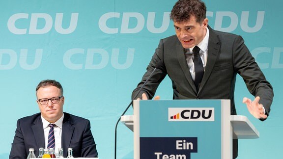 Mario Voigt (CDU, l), Partei- und Fraktionsvorsitzender, verfolgt bei der Landesvertreterversammlung der CDU im Kultur- und Kongresszentrum Festhalle Ilmenau die Rede von seinem Vorgänger Mike Mohring.