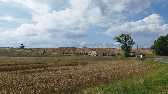 Rettungskräfte an einer Unfallstelle auf einer Landstraße.