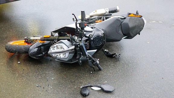 Ein liegendes Motorrad nach einem Unfall.