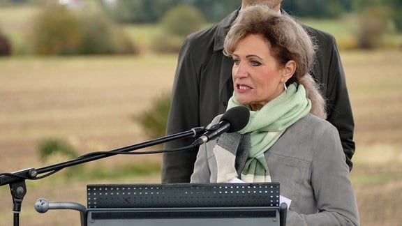 Eine Frau in grauer Jacke und mit dunkelblonden langen Haaren - die Thüringer Ministerin für Landwirtschaft und Infrastruktur, Birgit Keller - spricht an einem Podium in ein Mikrofon.