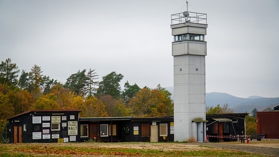 Ein alter Grenzwachturm steht neben Baracken.