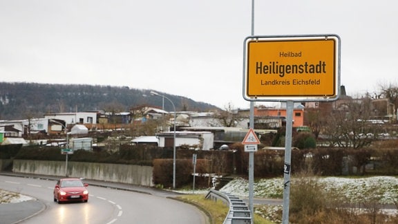 Ein Auto fährt am Ortseingangsschild der Stad Heiligenstadt im Eichsfeld Kreis vorbei.