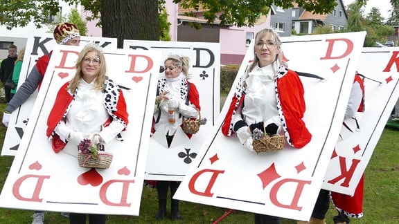 Mehrere als Spielkarten König und Dame verkleidete Personen auf einem Kirmes-Festumzug