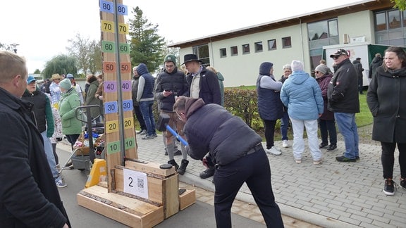 Mehrere Personen stehen um ein Hau-den-Lukas-Spiel herum.