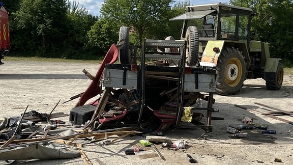 Ein Traktor mit einem umgestürzten Anhänger. 