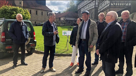 Landrat Werner Henning steht mit Mitgliedern des Kreistags im Hof von Klosterzella 