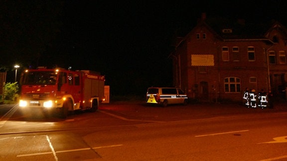Polizisten und einer Feuerwehrauto in Worbis bei Nacht.