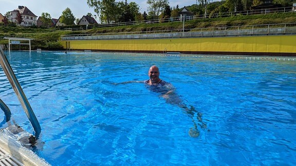 Ein Mann schwimmt im Becken eines Freibades.