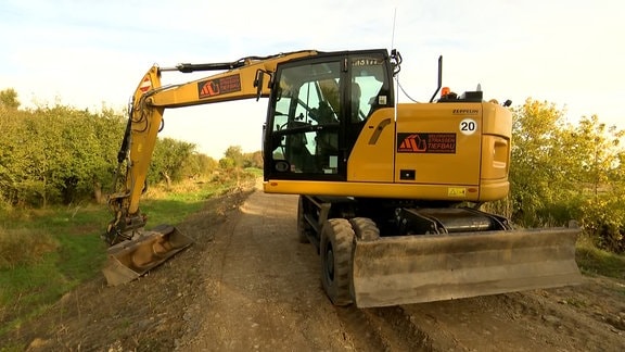 Ein Bagger steht auf einem Feldweg