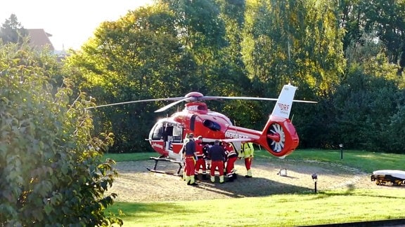 Sanitäter laden einen Patienten in einen Rettungshubschrauber.