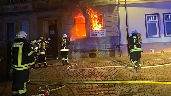 Einsatzkräfte der Feuerwehr löschen einen Brand.