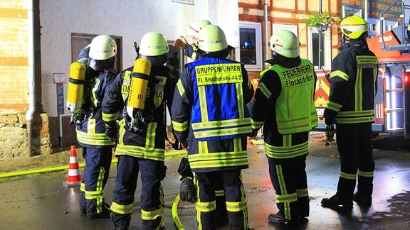 Feuerwehrmänner vor einem Haus