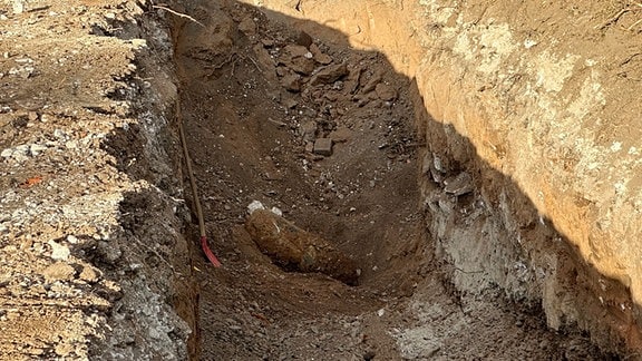 Eine Bombe aus dem Zweiten Weltkrieg liegt in einem Graben.