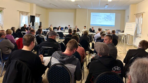  Vertreter des Thüringer Landesamts für Umwelt, Bergbau und Naturschutz diskutieren mit den Anwohner über den zukünftigen Hochwasserschutz von Windehausen.