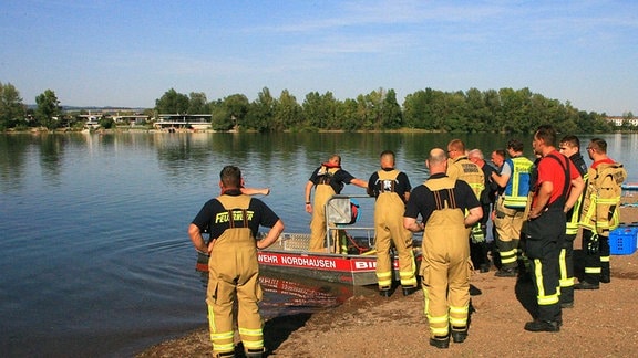 Mehrere Rettungskräfte an einem Seeufer