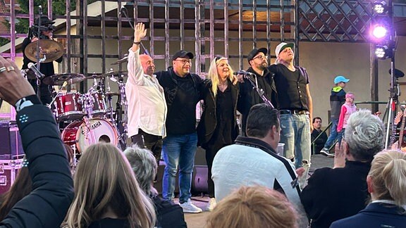 Fünf Bandmitglieder stehen auf der Bühne