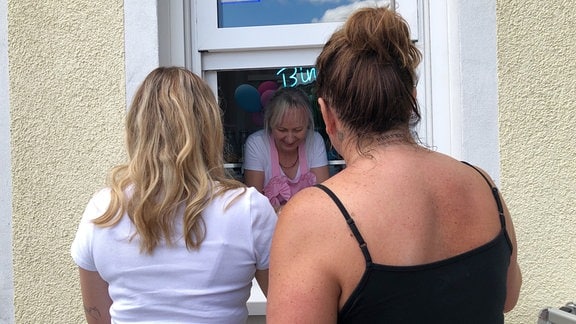Eine Frau verkauft Eis an zwei andere Frauen 