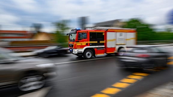 Eine Feuerwehrfahrzeug fährt im Stadtteil Loschwitz mit Blaulicht zu einem Einsatz.