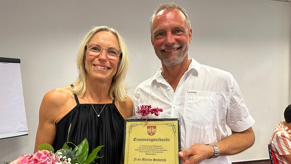 Marion Stedefeld präsentiert die Ehrenurkunde der Gemeinde Großengottern zusammen mit Dieter Facklam