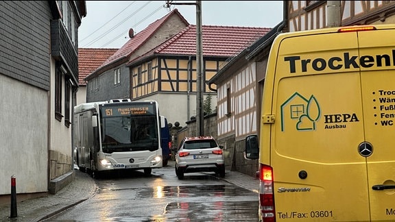 Ein Bus und Autos im oberen Drittel der engen Mühlhäuser Straße in Oberdorla.