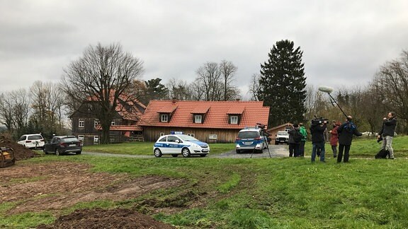 Zwei Polizeiautos und mehrere Reporter sowie ein Kamerateam stehen vor dem mit Holzbrettern verkleideten Wohnhaus des Thüringer AfD-Vorsitzenden Björn Höcke in Bornhagen im Eichsfeld