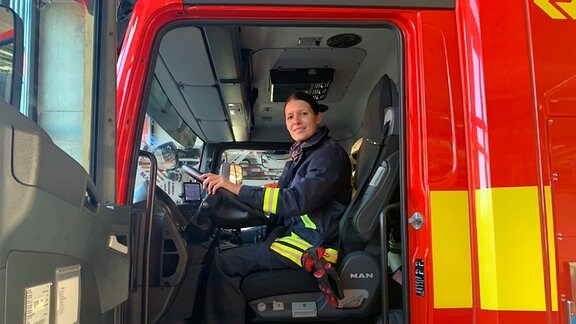 Hauptberufliche Feuerwehrfrau Anne Zwingenberger sitzt im Einsatzfahrzeug