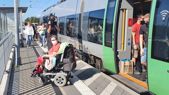 Eine Rollstuhlfahrerin an einem Bahnsteig. 