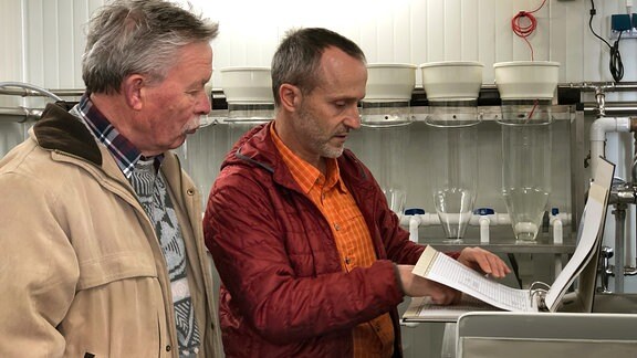 Die Angler Werner Schumann und Knuth Herrmann werfen einen prüfenden Blick auf Tabellen