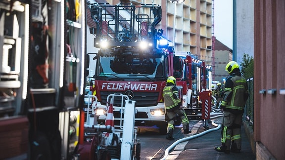 Feuerwehrleute löschen einen Brand in einem Wohnhaus in Gera