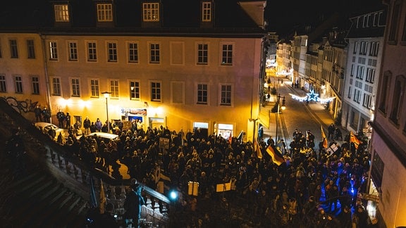 Bei Dunkelheit demonstrierende Menschenmenge auf engem Innenstadtplatz in Gera