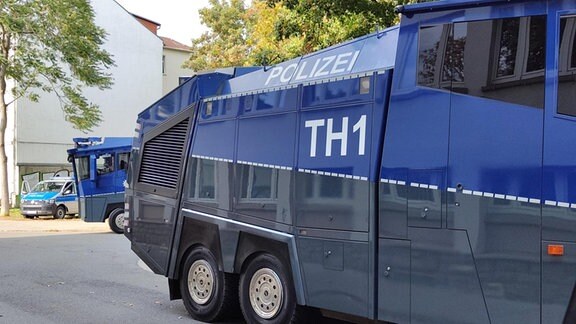 Wasserwerfer der Thüringer Polizei stehen in einer Straße.