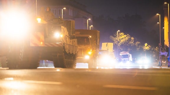 Ein Militärkonvoi der Bundeswehr fährt im Dunkeln durch eine Straße in Gera