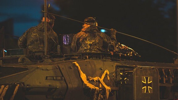 Zwei Soldaten sitzen auf einem Panzer
