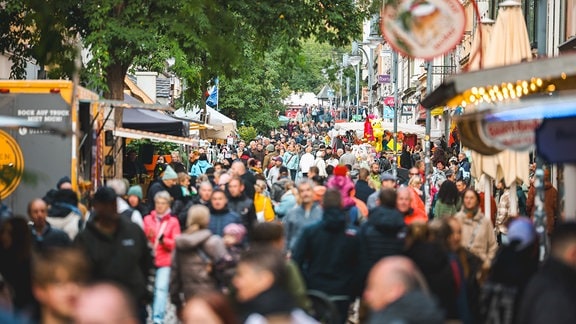 Menschen strömen durch die Innenstadt von Gera, in der zahlreiche Stände zum Höhlerfest aufgebaut sind