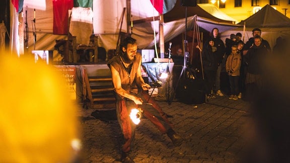 Ein Mann macht eine Vorführung mit Feuer auf dem Höhlerfest in Gera.