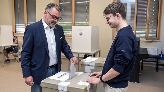 Der Geraer Oberbürgermeister Julian Vonarb steckt seinen Stimmzettel in die Wahlurne. 