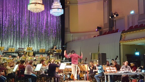 Ein Orchester spielt in einem Konzertsaal.