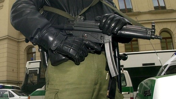 Ein Polizeibeamter mit Maschinenpistole im Anschlag