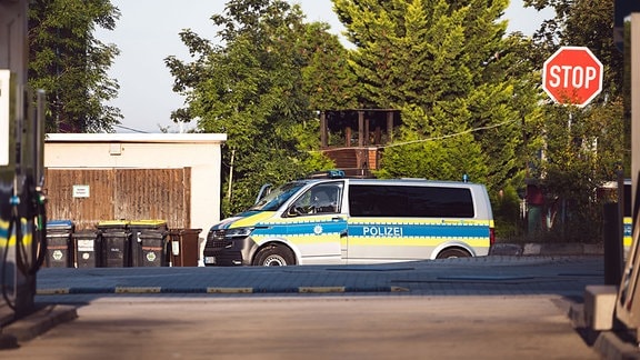 Ein Polizeiauto steht vor einer Garage.