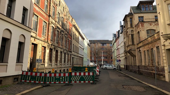 Häuserreihe mit Bauzaun vor einem Gebäude