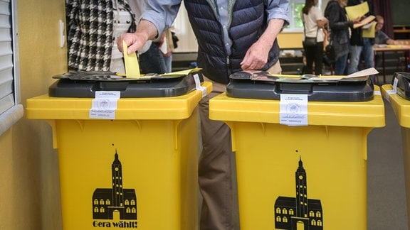 Gelbe Wahlurnen mit der Aufschrift "Gera wählt" stehen im Wahllokal in der Realschule "Otto Dix". 