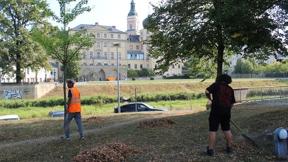 Menschen arbeiten in einem Park. 