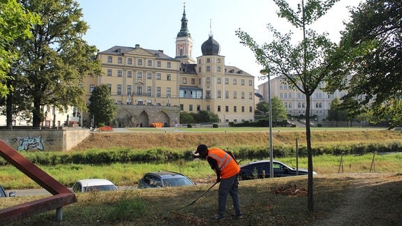 Ein Mann arbeitet in einem Park. 