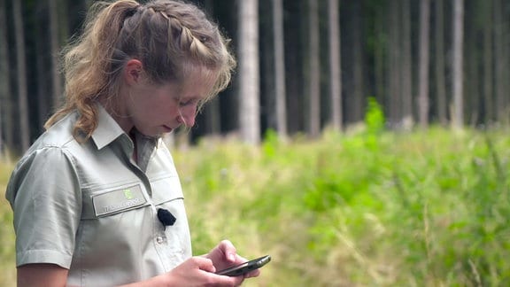Amelie Wohlleben erfasst mit einem Handy GPS-Daten.