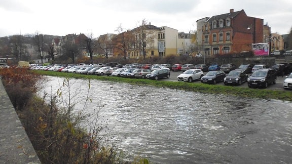 Auf einem Parkplatz an der Weißen Elster in Greiz stehen zahlreiche Autos unter anderem aus Sachsen, da am Buß- und Bettag viele sächsische Arbeitnehmer zum Einkaufen nach Ostthüringen kommen