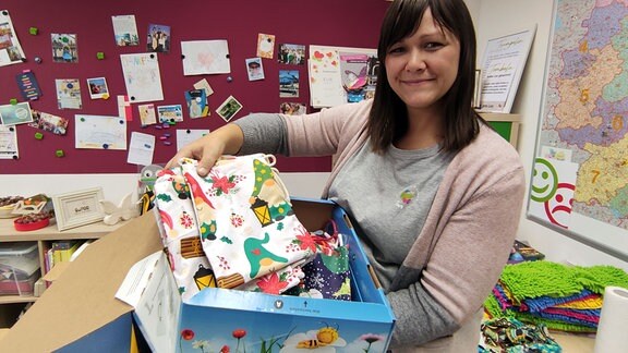 Ina Barth zeigt eine Kiste mit Nikolausstiefeln für das Klinikum Greifswald.